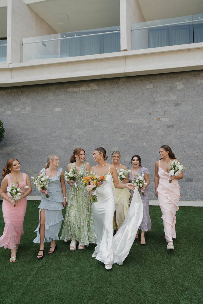 bride and bridesmaids wearing mismatched pastel dresses
