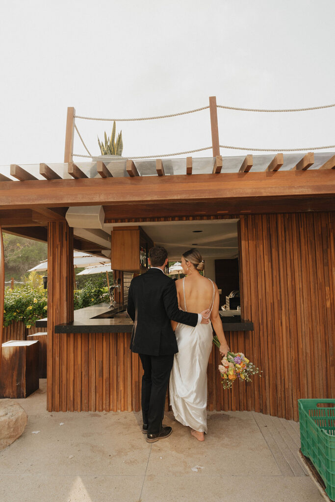 bride and groom standing at a cabana