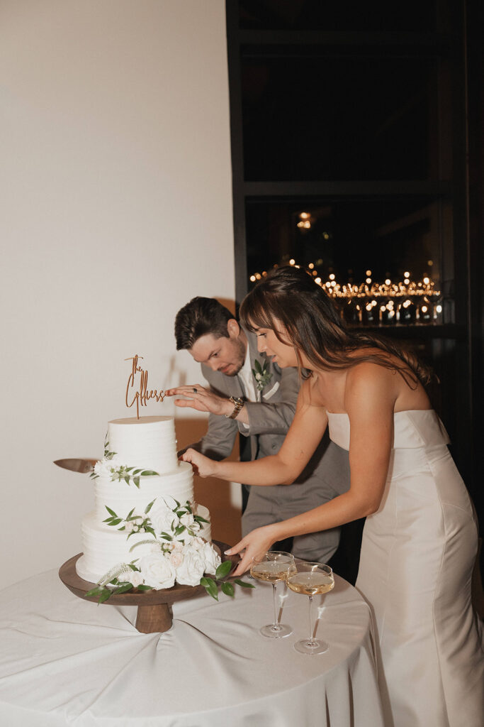 couple cutting white wedding cake