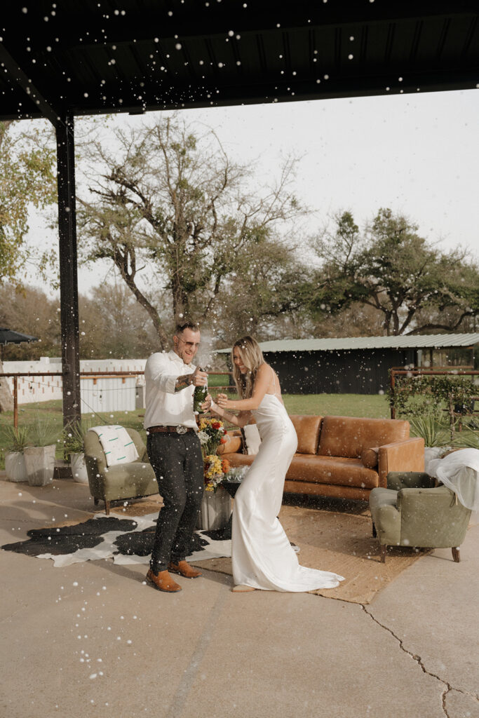 bride and groom pop champagne after elopement ceremony