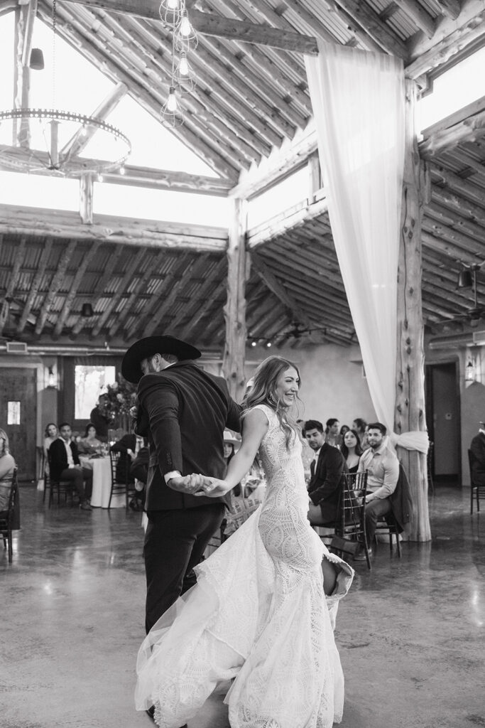 The couple, dressed in western-inspired attire, sharing a dance during their classy western wedding reception.