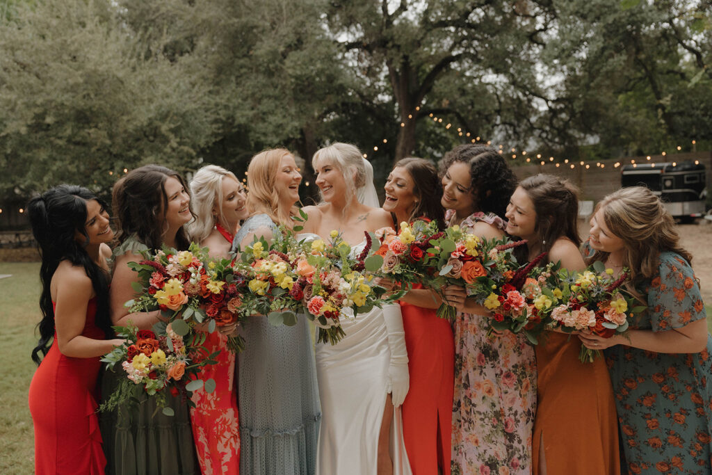 bridesmaid and bride wearing multi color bridesmaid dresses